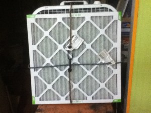 Here it is! A food dehydrator made of furnace filters and a box fan. Note the industrial chic bungee chords holding it all together.