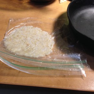 It took a few tries, but I figured out a way to make forming the crackers easier. I used a sandwich bag split open on three sides. I wet my hand and the bag with water. I rolled a little ball of rice in my dampened hands and but it between the layers of the bag. Then I smashed the ball with my smaller cast iron skillet.The weight of the skillet did all the work! 