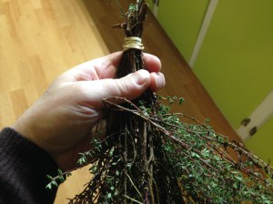 Once your herbs are dirt and caterpillar free shake off the excess water and blot with towels. Once dry, make little bundles of herbs. I like to use rubber bands for this because they will stay tight if the stems shrink as they dry. If you want, you can hang your bundles as is. However, exposure to light will fade the color and the flavor of your herbs. But there is a way to avoid that...