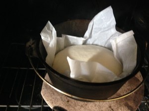 Heat the regular oven with the Dutch oven inside. When the oven oven has heated, carefully lift the corners of the parchment and drop the dough into the hot Dutch oven. Put the lid on the Dutch oven then close the oven oven.